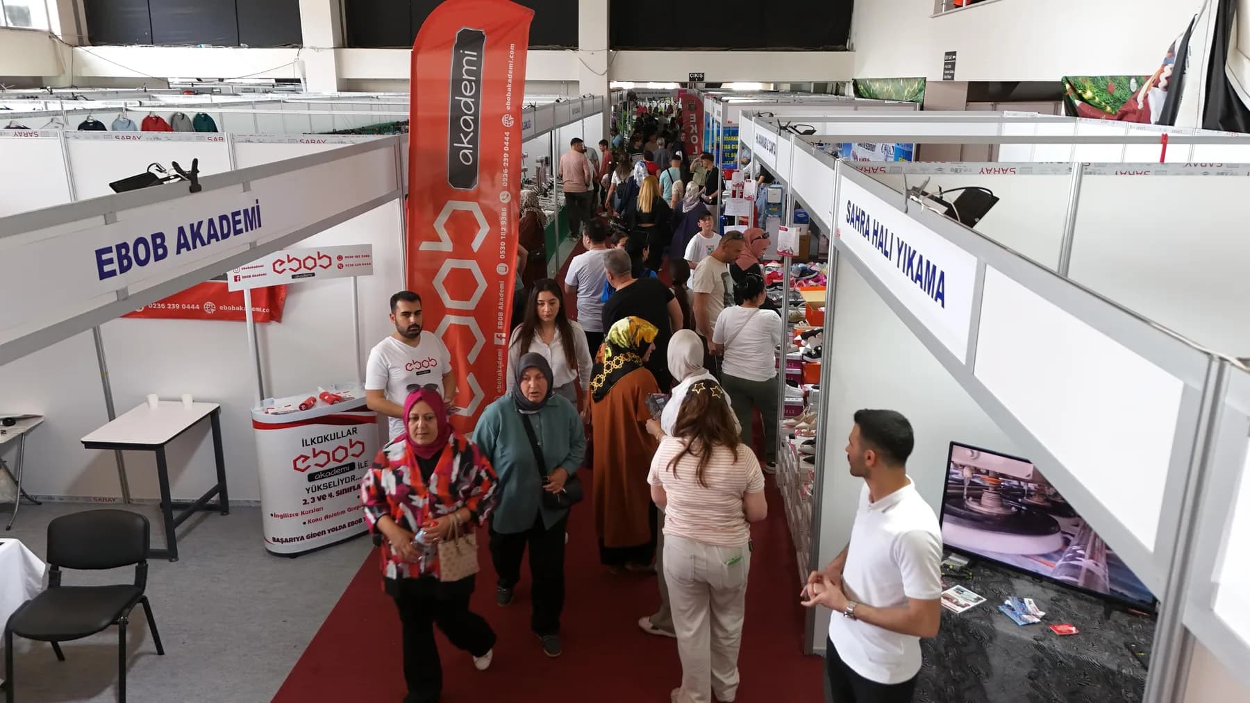 Salon koridorunda stantlar arasında yürüyen ziyaretçiler