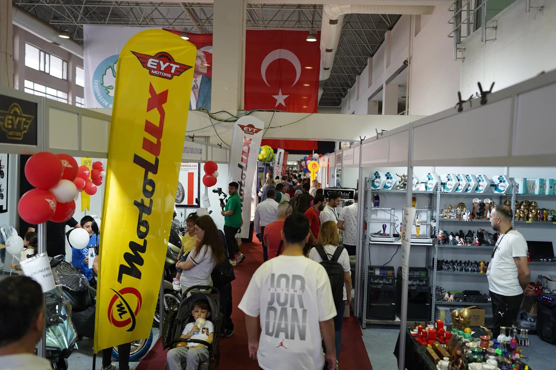 Koridorda flamalar ve balonlar arasında ilerleyen ziyaretçiler